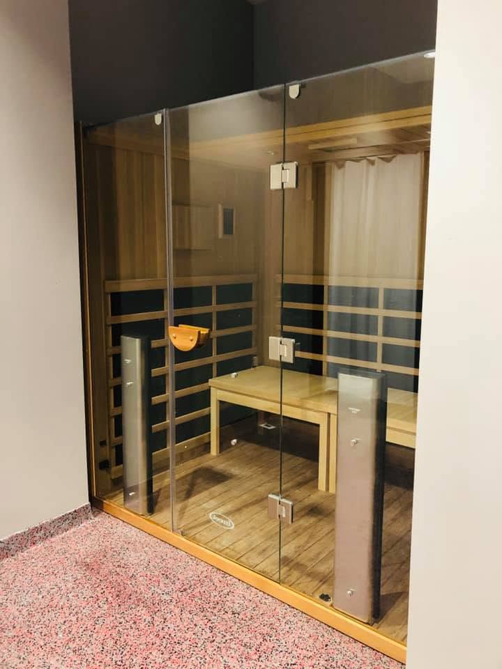 Inside the infrared sauna: cedar benches behind the glass front